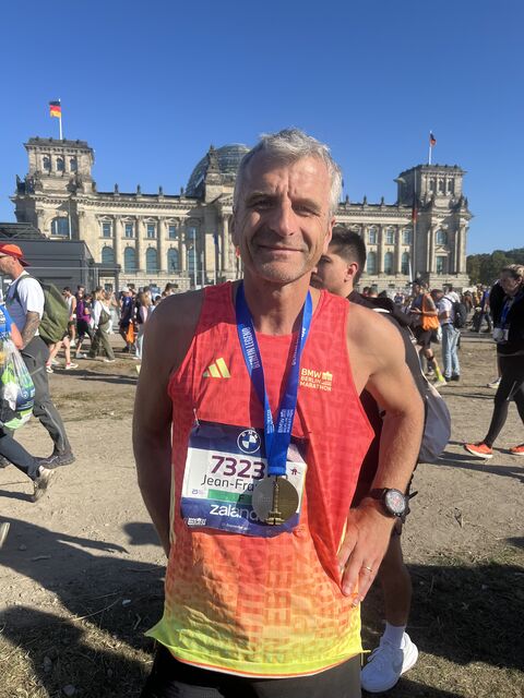 Jean-François Perchot, médaille du marathon de Berlin autour du cou, devant le Reichstag