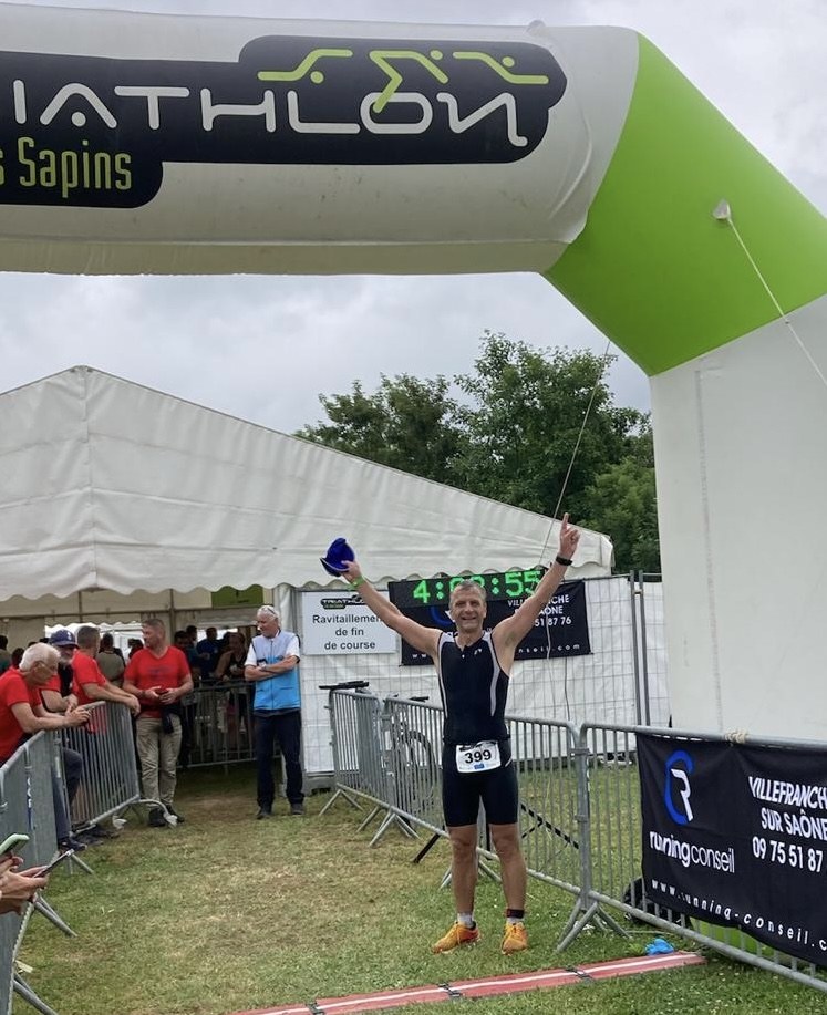 Jean-François Perchot franchit la ligne d'arrivée du triathlon du lac des Sapins, les bras levés